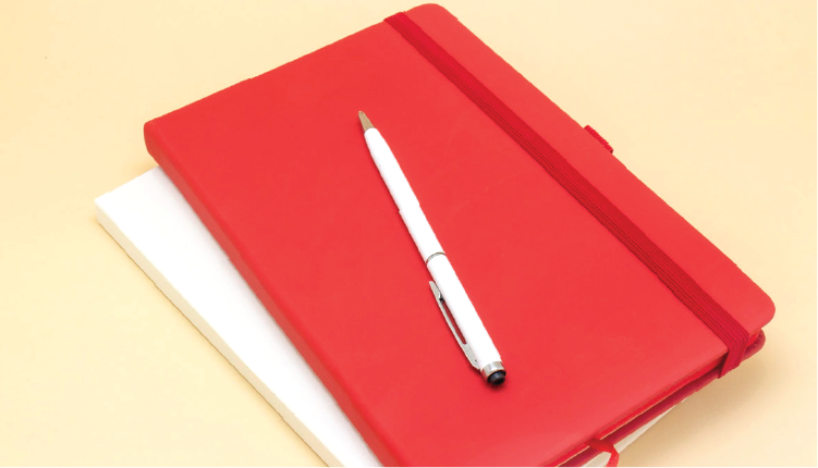 An image showing an A5 PU leather notebook. It is in red colour, it can be customised with respective company logos.